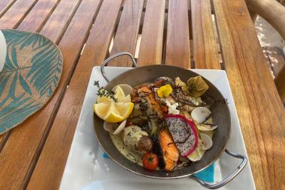 Bouteilles de vin rosé sur glace devant des parasols blancs et bleus sous un ciel dégagé.