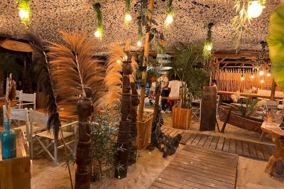 Bouteilles de vin rosé sur glace devant des parasols blancs et bleus sous un ciel dégagé.