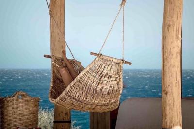 Bouteilles de vin rosé sur glace devant des parasols blancs et bleus sous un ciel dégagé.