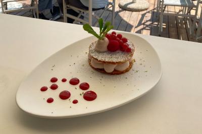Bouteilles de vin rosé sur glace devant des parasols blancs et bleus sous un ciel dégagé.