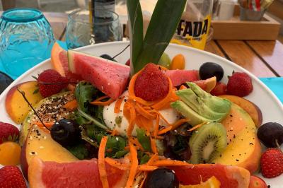 Bouteilles de vin rosé sur glace devant des parasols blancs et bleus sous un ciel dégagé.