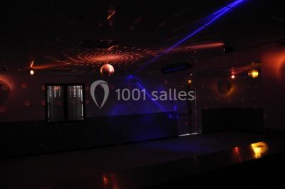 Panneau blanc avec le mot ’PARKING’ en noir et une flèche noire pointant vers la droite, fixé sur un sol en béton.