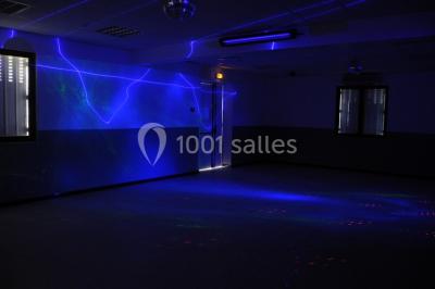 Panneau blanc avec le mot ’PARKING’ en noir et une flèche noire pointant vers la droite, fixé sur un sol en béton.