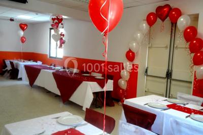 Panneau blanc avec le mot ’PARKING’ en noir et une flèche noire pointant vers la droite, fixé sur un sol en béton.