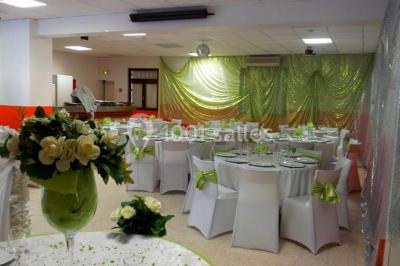 Panneau blanc avec le mot ’PARKING’ en noir et une flèche noire pointant vers la droite, fixé sur un sol en béton.