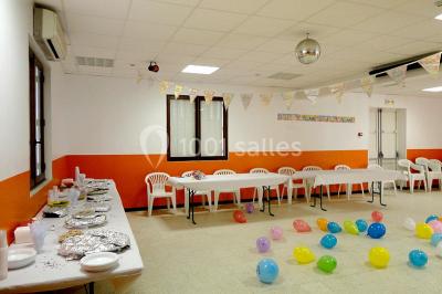 Panneau blanc avec le mot ’PARKING’ en noir et une flèche noire pointant vers la droite, fixé sur un sol en béton.