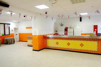 Panneau blanc avec le mot ’PARKING’ en noir et une flèche noire pointant vers la droite, fixé sur un sol en béton.