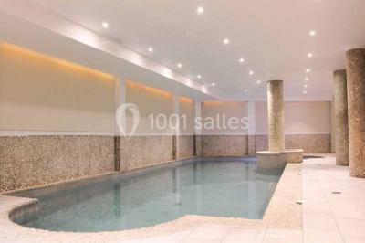 Deux équipements de fitness, un tapis de course et un vélo elliptique, dans une salle au sol en bois et murs bleus.