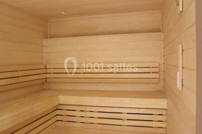 Deux équipements de fitness, un tapis de course et un vélo elliptique, dans une salle au sol en bois et murs bleus.