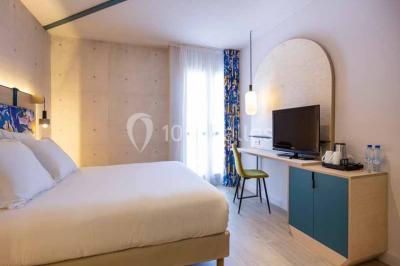 Deux équipements de fitness, un tapis de course et un vélo elliptique, dans une salle au sol en bois et murs bleus.