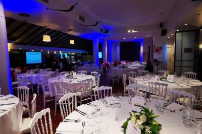 Deux équipements de fitness, un tapis de course et un vélo elliptique, dans une salle au sol en bois et murs bleus.