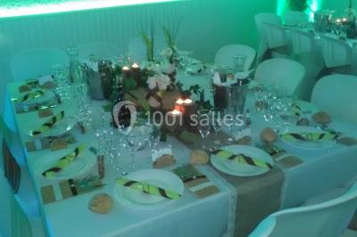 Jeu de lumières colorées dans une salle sombre avec équipement de sonorisation visible en arrière-plan.