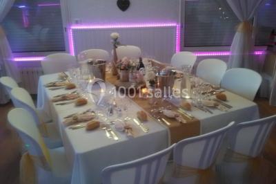 Jeu de lumières colorées dans une salle sombre avec équipement de sonorisation visible en arrière-plan.