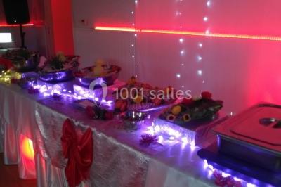 Jeu de lumières colorées dans une salle sombre avec équipement de sonorisation visible en arrière-plan.