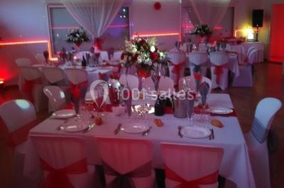 Jeu de lumières colorées dans une salle sombre avec équipement de sonorisation visible en arrière-plan.