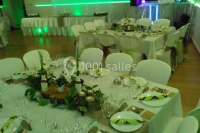 Jeu de lumières colorées dans une salle sombre avec équipement de sonorisation visible en arrière-plan.