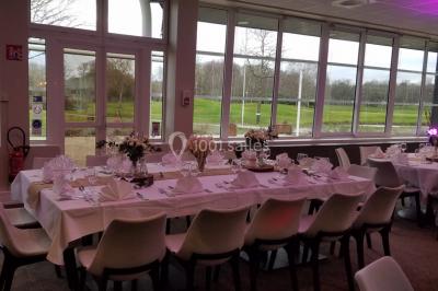 Plan d'eau entouré de pelouses et d'arbres, avec deux bouleaux au premier plan sous un ciel bleu.