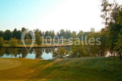 Plan d'eau entouré de pelouses et d'arbres, avec deux bouleaux au premier plan sous un ciel bleu.