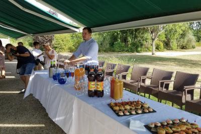 Étang entouré de pelouses et de bouleaux sous un ciel bleu clair.