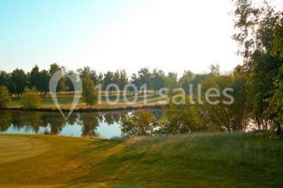 Étang entouré de pelouses et de bouleaux sous un ciel bleu clair.