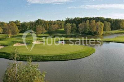 Étang entouré de pelouses et de bouleaux sous un ciel bleu clair.