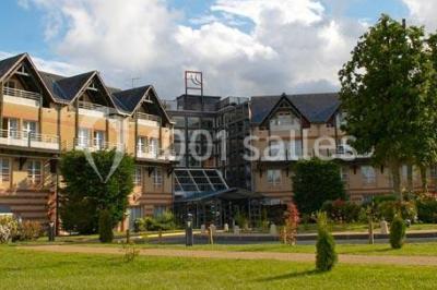 Étang entouré de pelouses et de bouleaux sous un ciel bleu clair.