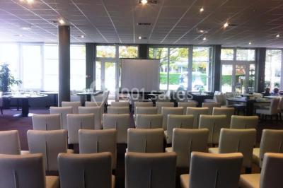 Étang entouré de pelouses et de bouleaux sous un ciel bleu clair.