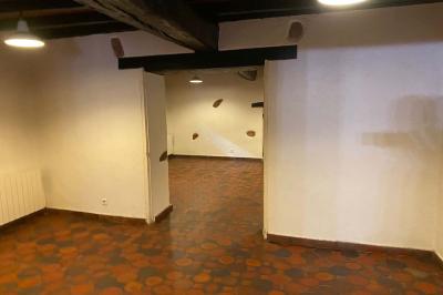 Deux réfrigérateurs blancs dans une pièce avec un sol en carrelage rouge, une porte en bois et un plan de travail.