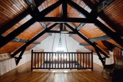 Deux réfrigérateurs blancs dans une pièce avec un sol en carrelage rouge, une porte en bois et un plan de travail.