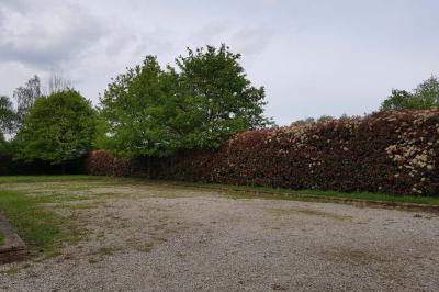 Deux réfrigérateurs blancs dans une pièce avec un sol en carrelage rouge, une porte en bois et un plan de travail.