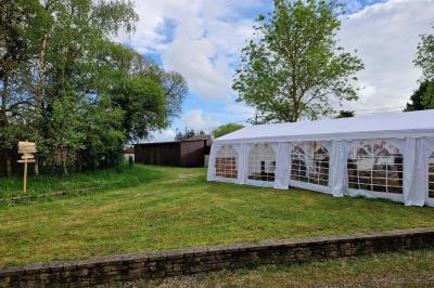 Deux réfrigérateurs blancs dans une pièce avec un sol en carrelage rouge, une porte en bois et un plan de travail.