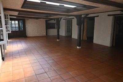 Deux réfrigérateurs blancs dans une pièce avec un sol en carrelage rouge, une porte en bois et un plan de travail.