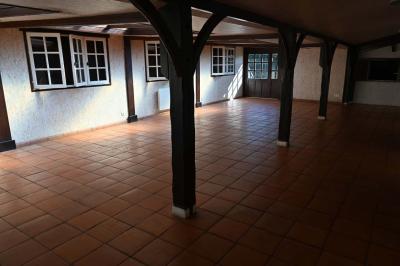 Deux réfrigérateurs blancs dans une pièce avec un sol en carrelage rouge, une porte en bois et un plan de travail.