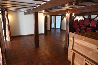 Deux réfrigérateurs blancs dans une pièce avec un sol en carrelage rouge, une porte en bois et un plan de travail.