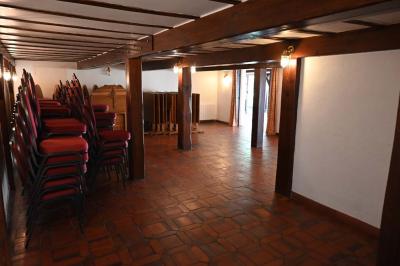 Deux réfrigérateurs blancs dans une pièce avec un sol en carrelage rouge, une porte en bois et un plan de travail.