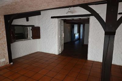 Deux réfrigérateurs blancs dans une pièce avec un sol en carrelage rouge, une porte en bois et un plan de travail.