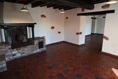 Deux réfrigérateurs blancs dans une pièce avec un sol en carrelage rouge, une porte en bois et un plan de travail.