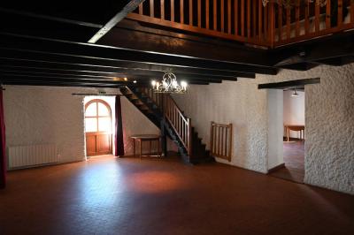 Deux réfrigérateurs blancs dans une pièce avec un sol en carrelage rouge, une porte en bois et un plan de travail.