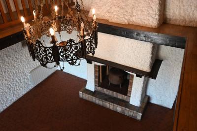 Deux réfrigérateurs blancs dans une pièce avec un sol en carrelage rouge, une porte en bois et un plan de travail.