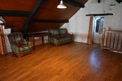 Deux réfrigérateurs blancs dans une pièce avec un sol en carrelage rouge, une porte en bois et un plan de travail.