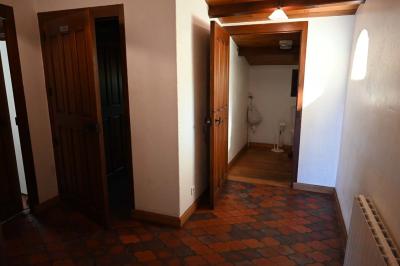 Deux réfrigérateurs blancs dans une pièce avec un sol en carrelage rouge, une porte en bois et un plan de travail.