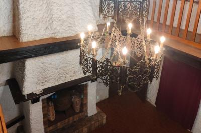 Deux réfrigérateurs blancs dans une pièce avec un sol en carrelage rouge, une porte en bois et un plan de travail.