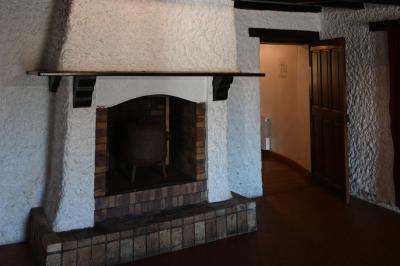 Deux réfrigérateurs blancs dans une pièce avec un sol en carrelage rouge, une porte en bois et un plan de travail.