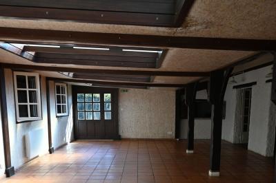 Deux réfrigérateurs blancs dans une pièce avec un sol en carrelage rouge, une porte en bois et un plan de travail.