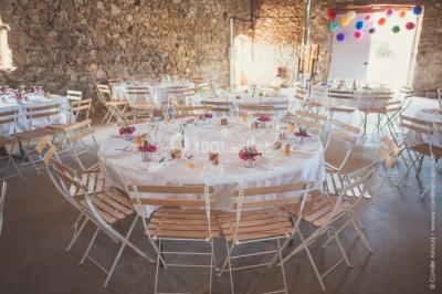 Chambre avec un lit double, draps blancs, couverture rouge, deux oreillers bleus et un mur rouge, éclairée par une fenêtre.