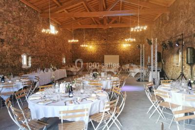 Chambre avec un lit double, draps blancs, couverture rouge, deux oreillers bleus et un mur rouge, éclairée par une fenêtre.