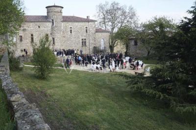 Chambre avec un lit double, draps blancs, couverture rouge, deux oreillers bleus et un mur rouge, éclairée par une fenêtre.