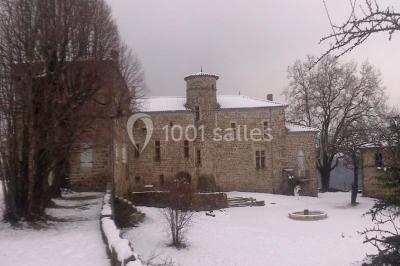 Chambre avec un lit double, draps blancs, couverture rouge, deux oreillers bleus et un mur rouge, éclairée par une fenêtre.