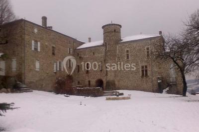 Chambre avec un lit double, draps blancs, couverture rouge, deux oreillers bleus et un mur rouge, éclairée par une fenêtre.
