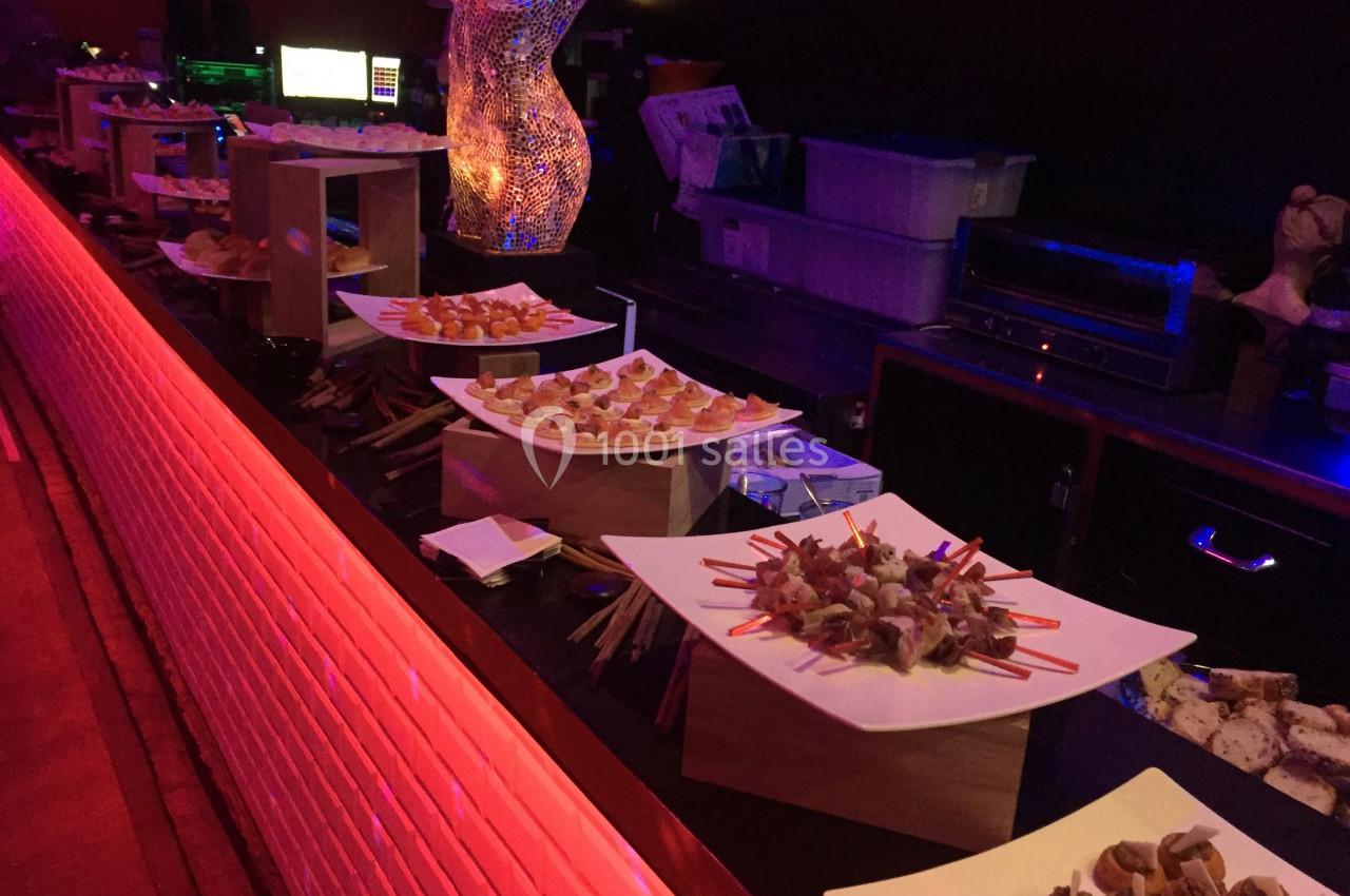 Buffet de bouchées apéritives variées disposées sur des présentoirs dans un cadre tamisé.